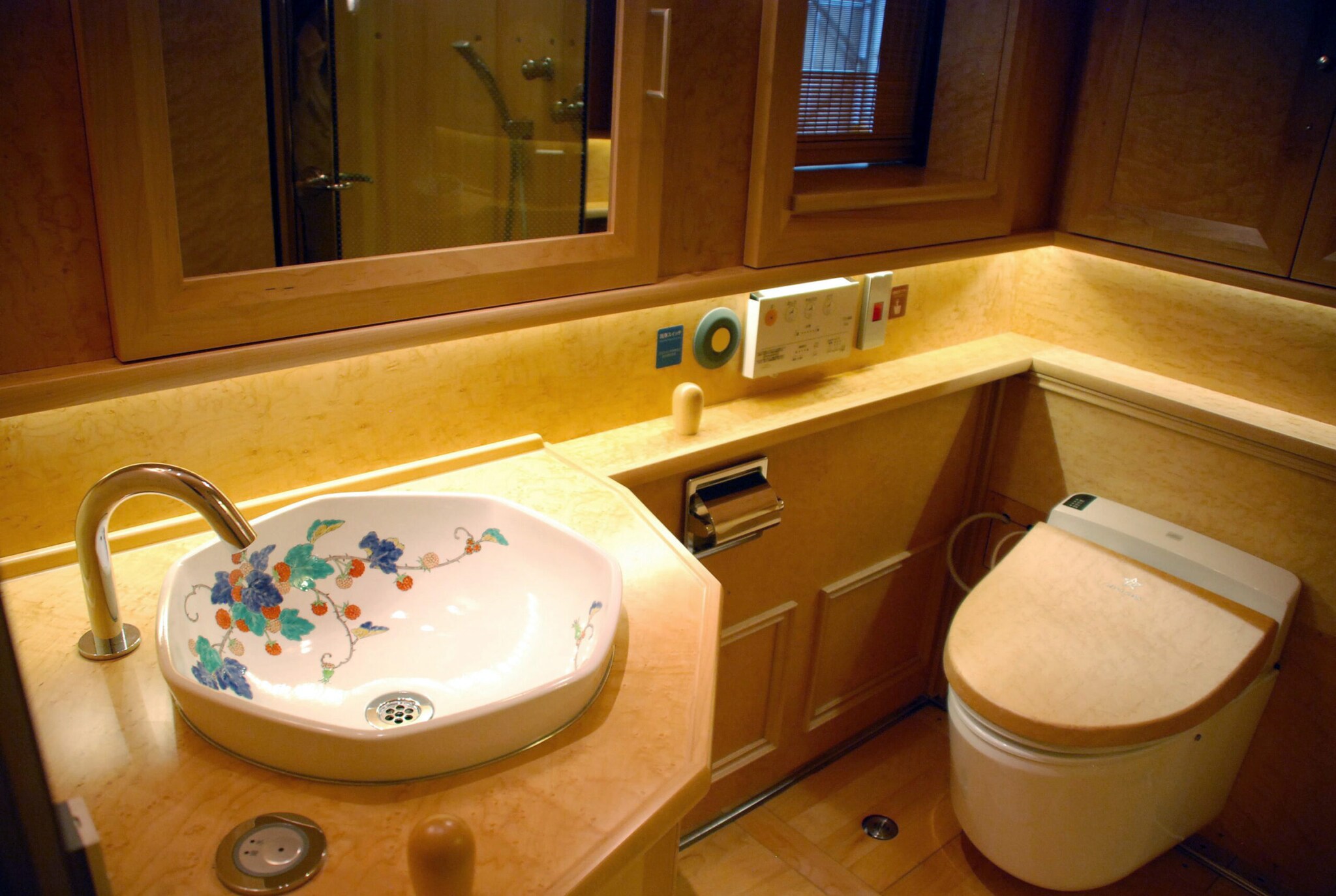 Luxuriöses Bad in einem Reisezug mit bemaltem Porzellanwaschbecken und beheizbarer Toilette
