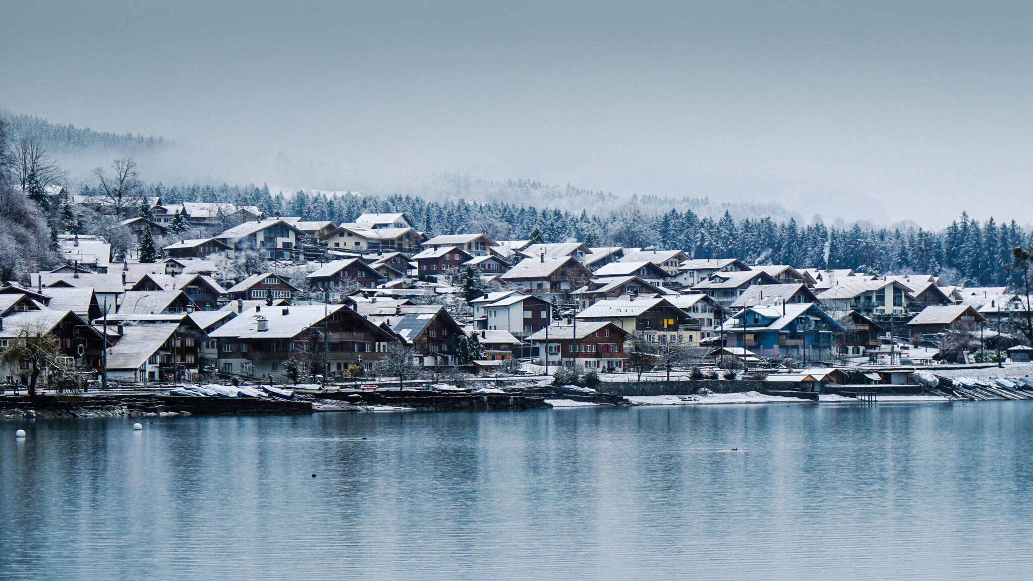 Ein schneebedecktes Dorf an einem See