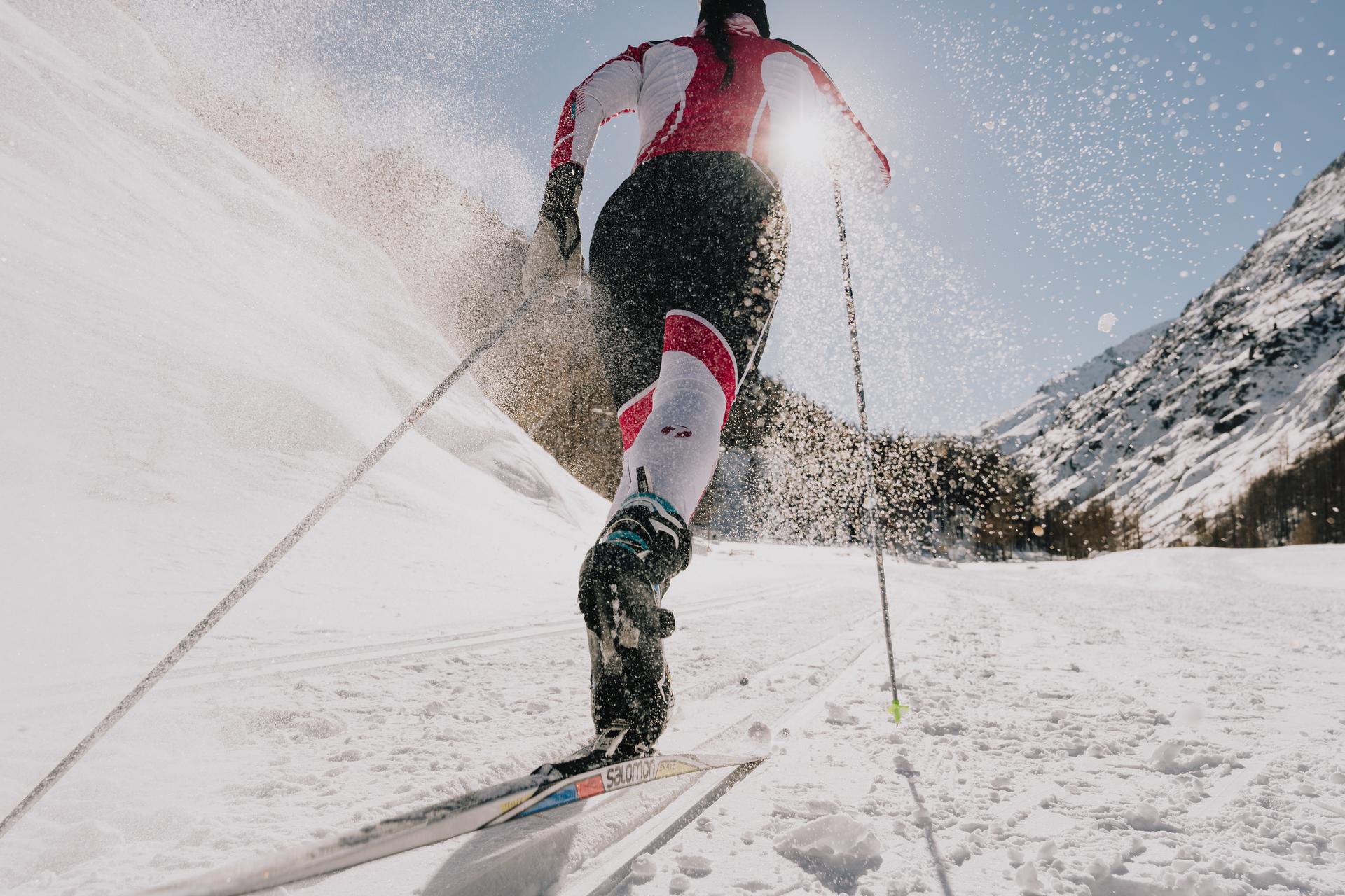 Sicht von schräg unten, eine Person fährt Langlauf in den Bergen Sicht von schräg unten, eine Person fährt Langlauf in den Bergen