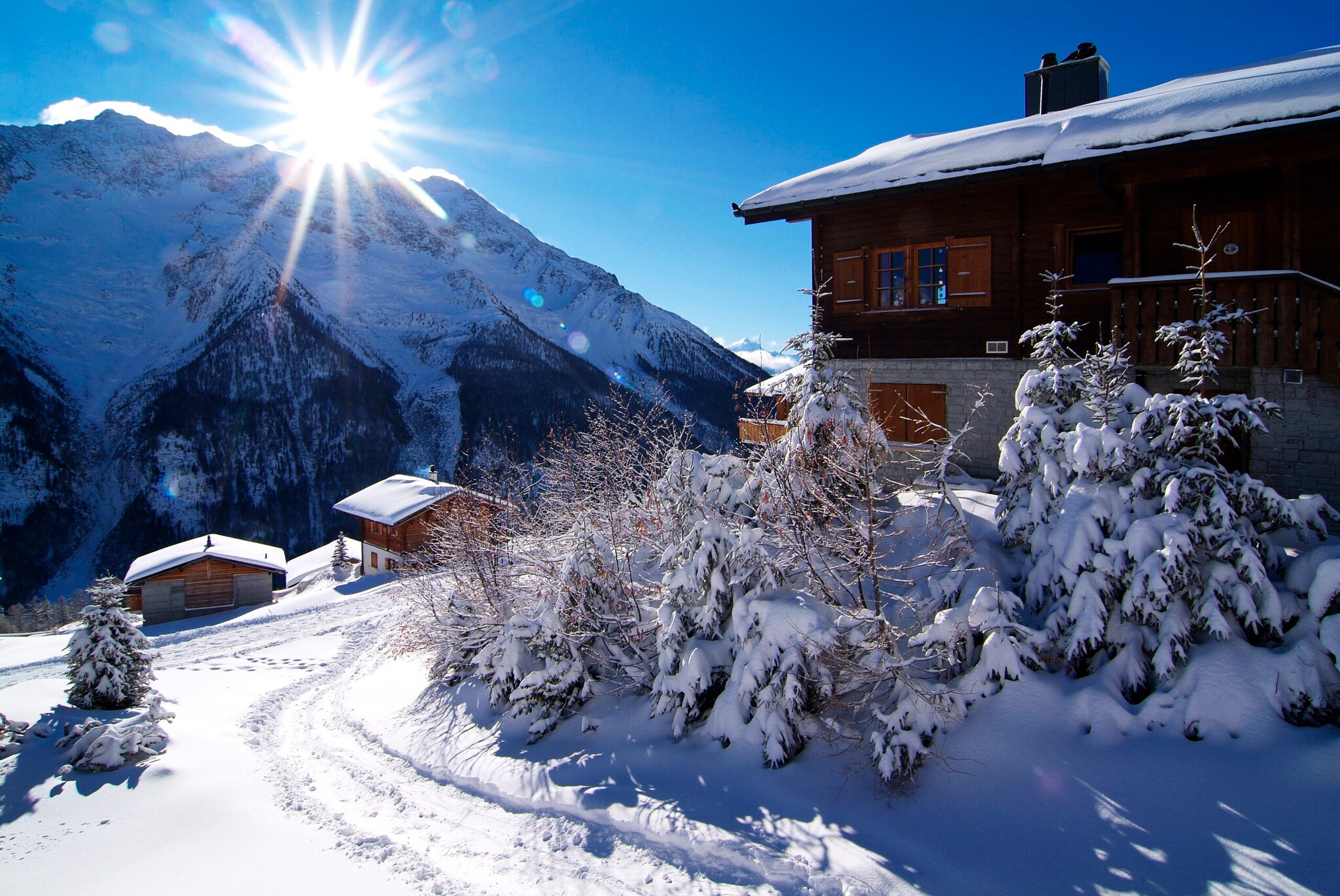 Mehrere Holzhütten in einer verschneiten Berglandschaft