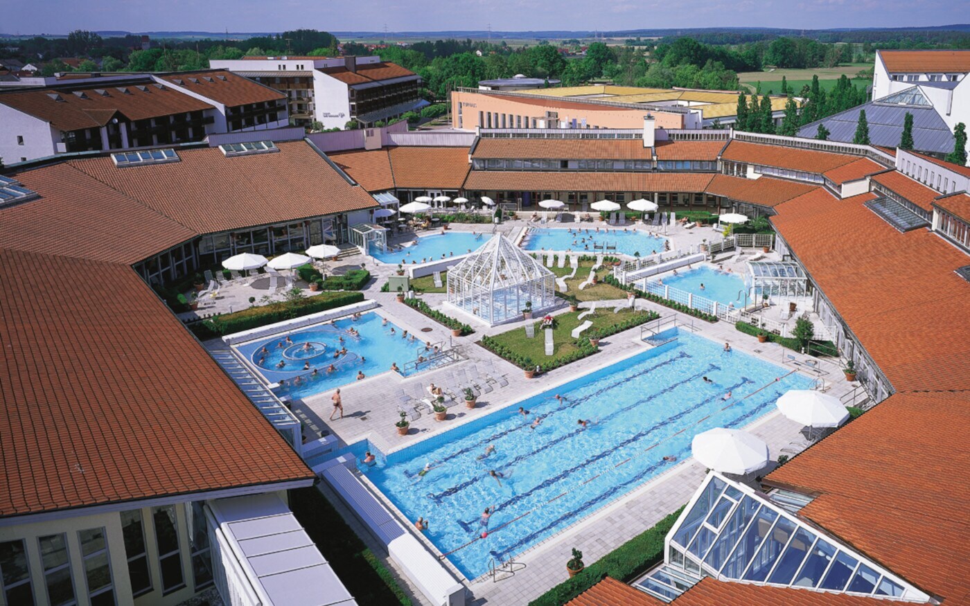 Panoramablick auf eine großflächigen Poollandschaft im Außenbereich einer Badeanstalt