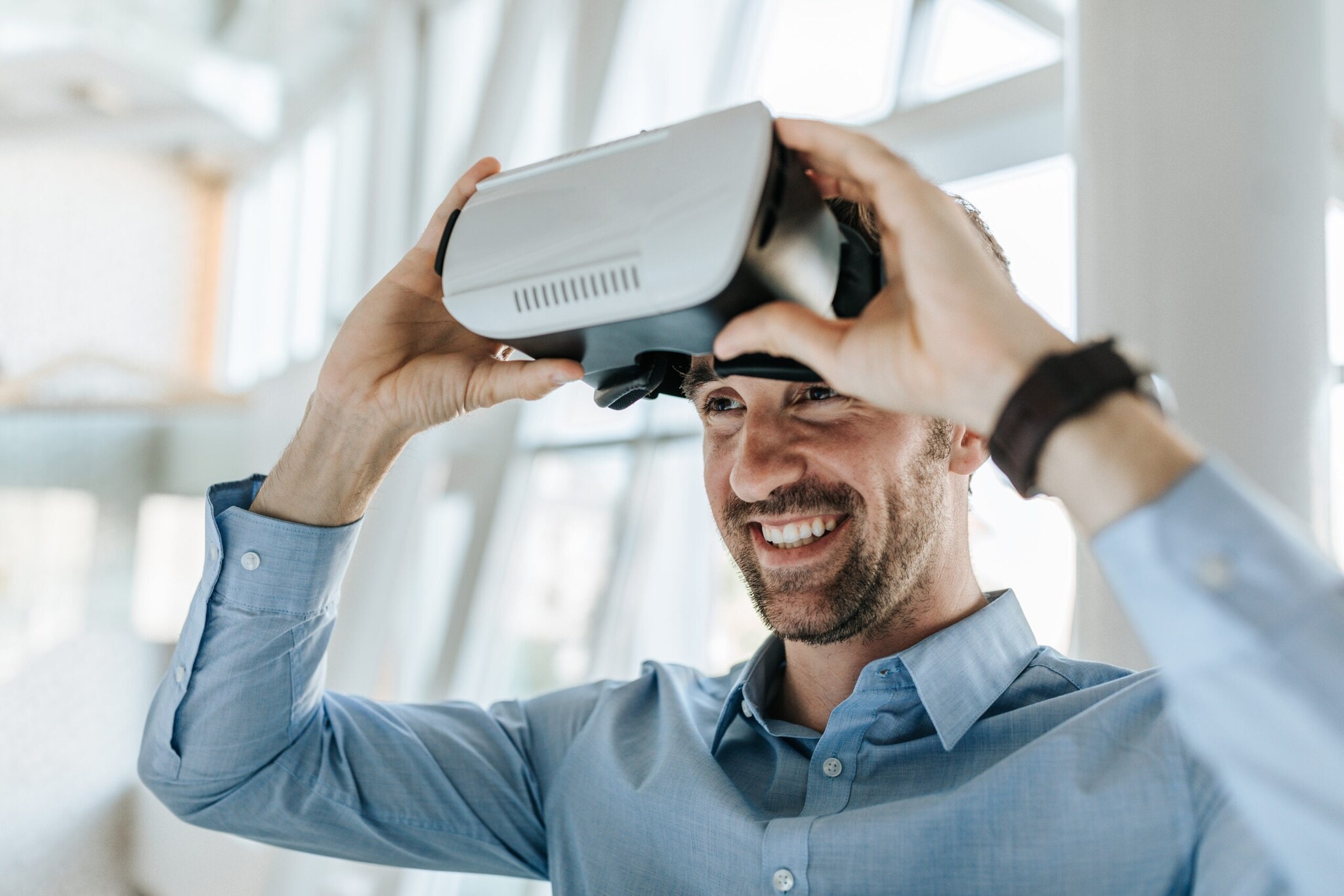Ein junger Mann setzt eine VR-Brille ab. Ein junger Mann setzt eine VR-Brille ab.