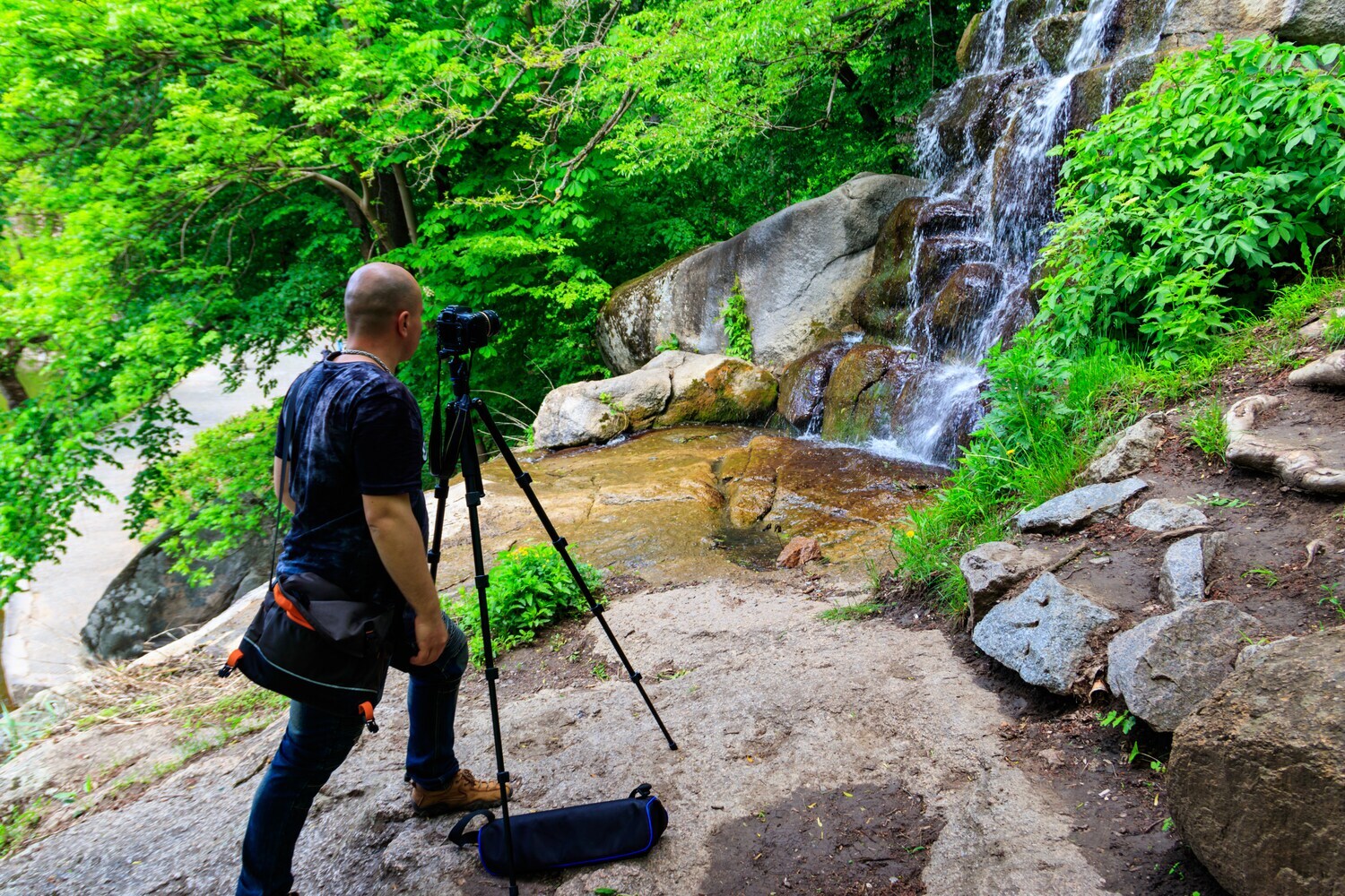 Ein Fotograf an einem Wasserfall.