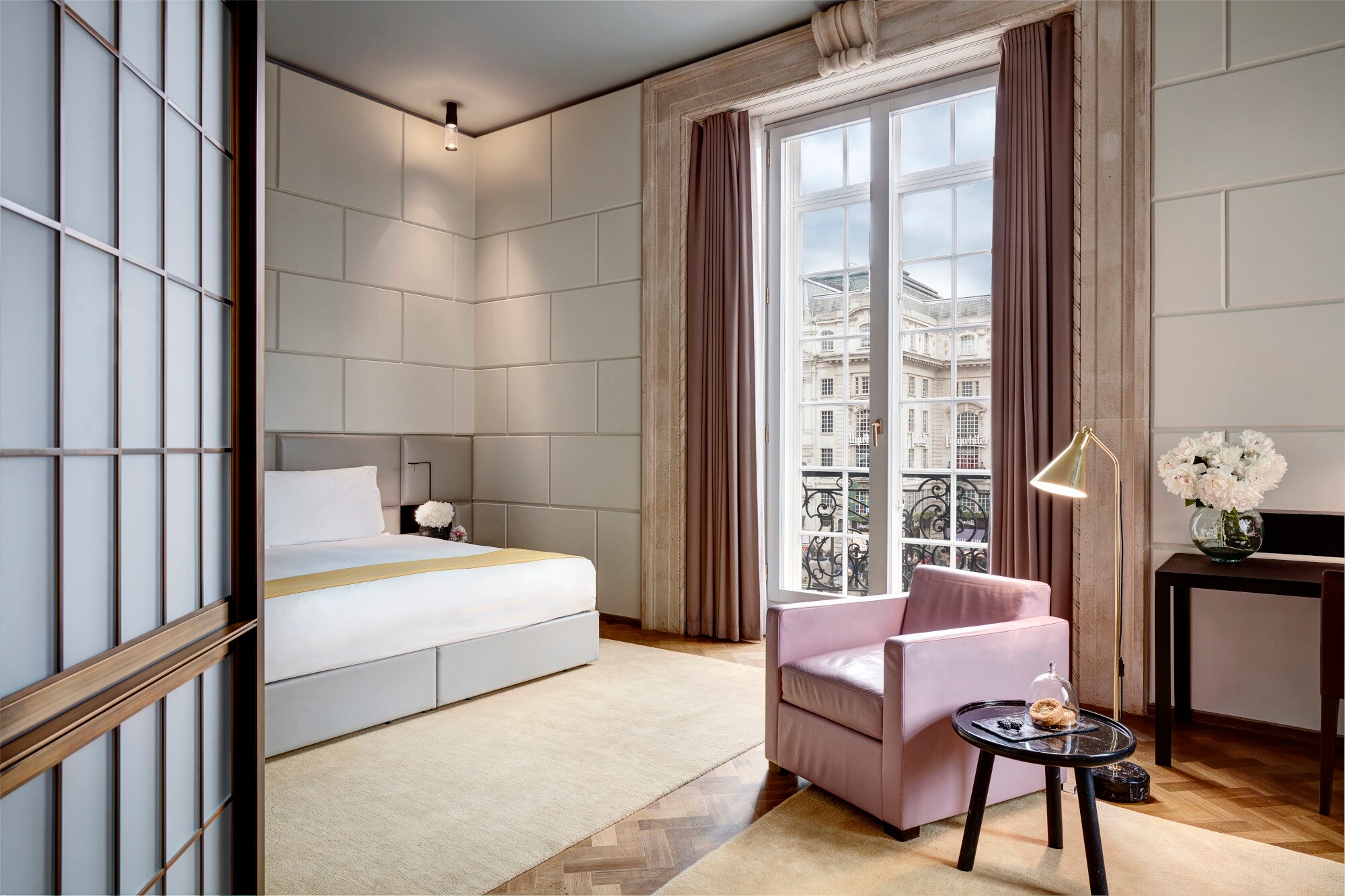 Eine moderne, luxuriöse Hotelsuite in Pastelltönen und einem Jugendstilbalkon inklusive Panoramafenster und Blick ins Stadtzentrum Eine moderne, luxuriöse Hotelsuite in Pastelltönen und einem Jugendstilbalkon inklusive Panoramafenster und Blick ins Stadtzentrum