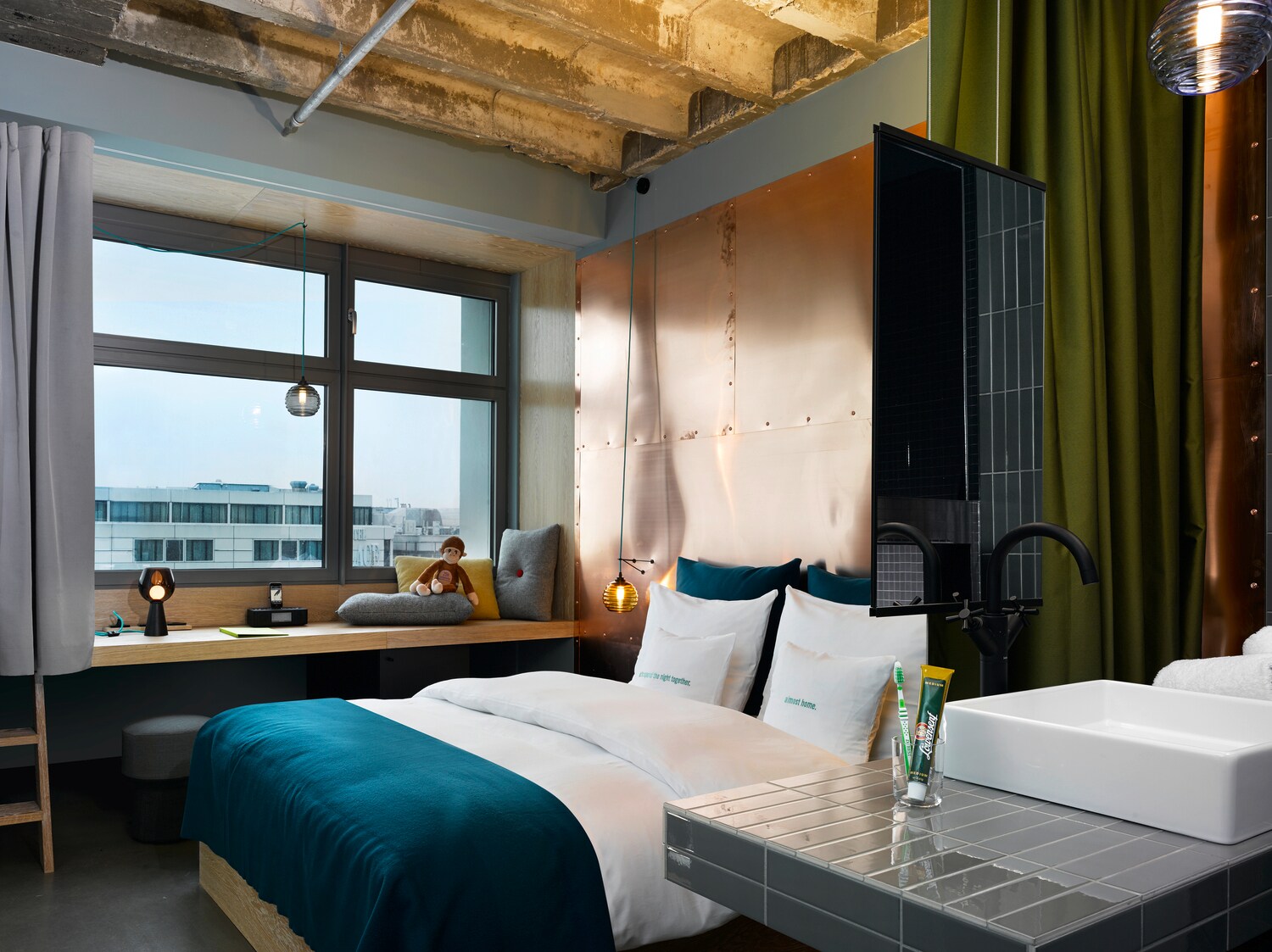 Innenansicht eines Hotelzimmers mit Kupferelementen, Doppelbett und Blick über Berlin