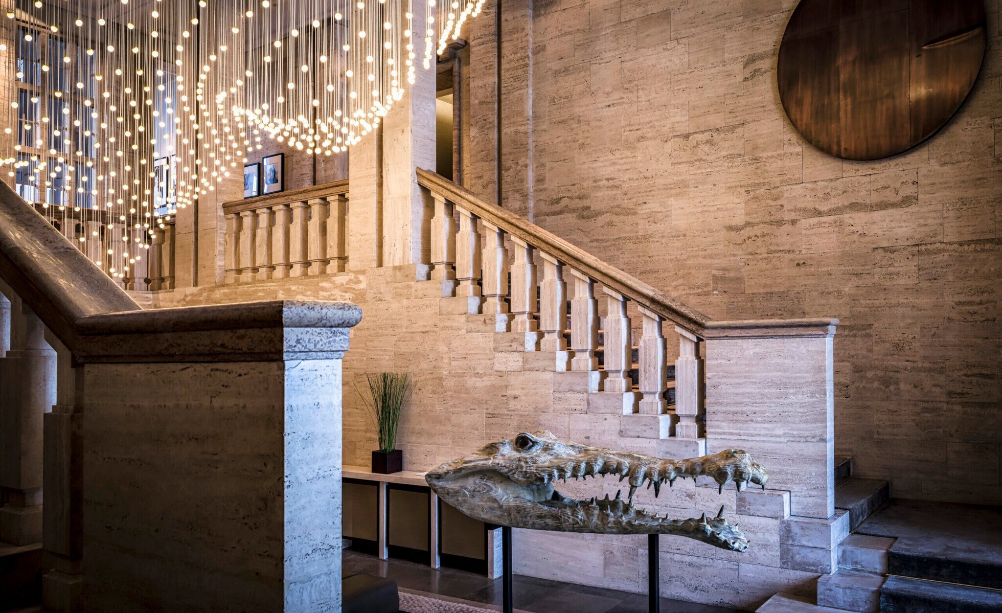 Innenansicht einer Hotellobby mit Treppenaufgang und einem Krokodilschädel