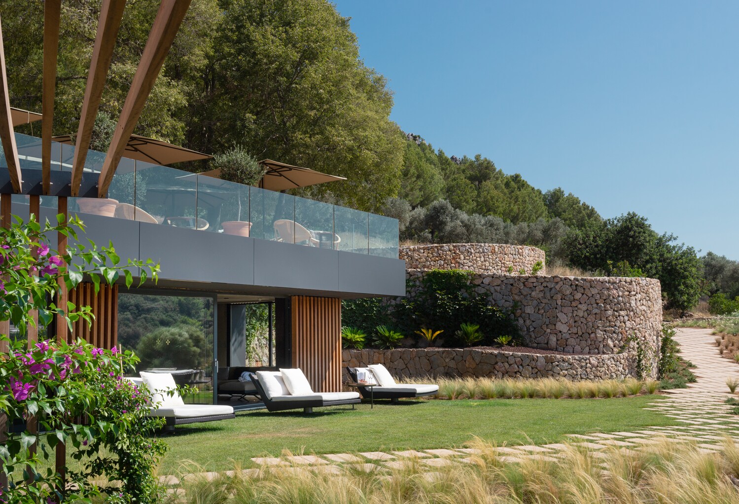 Eine Hotelanlage mit großer Terrasse inmitten von Natur