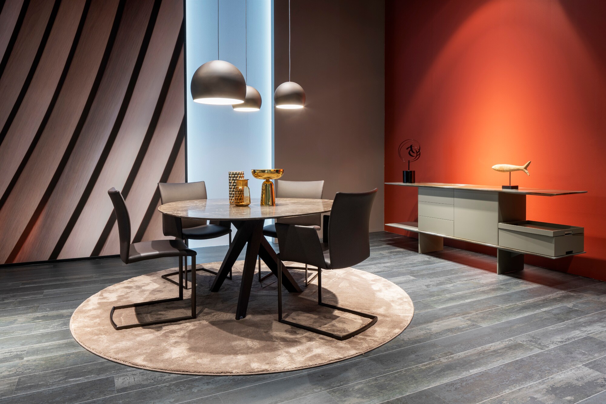 Ein runder Tisch und ein schlichtes Sideboard auf einem Messestand der imm cologne