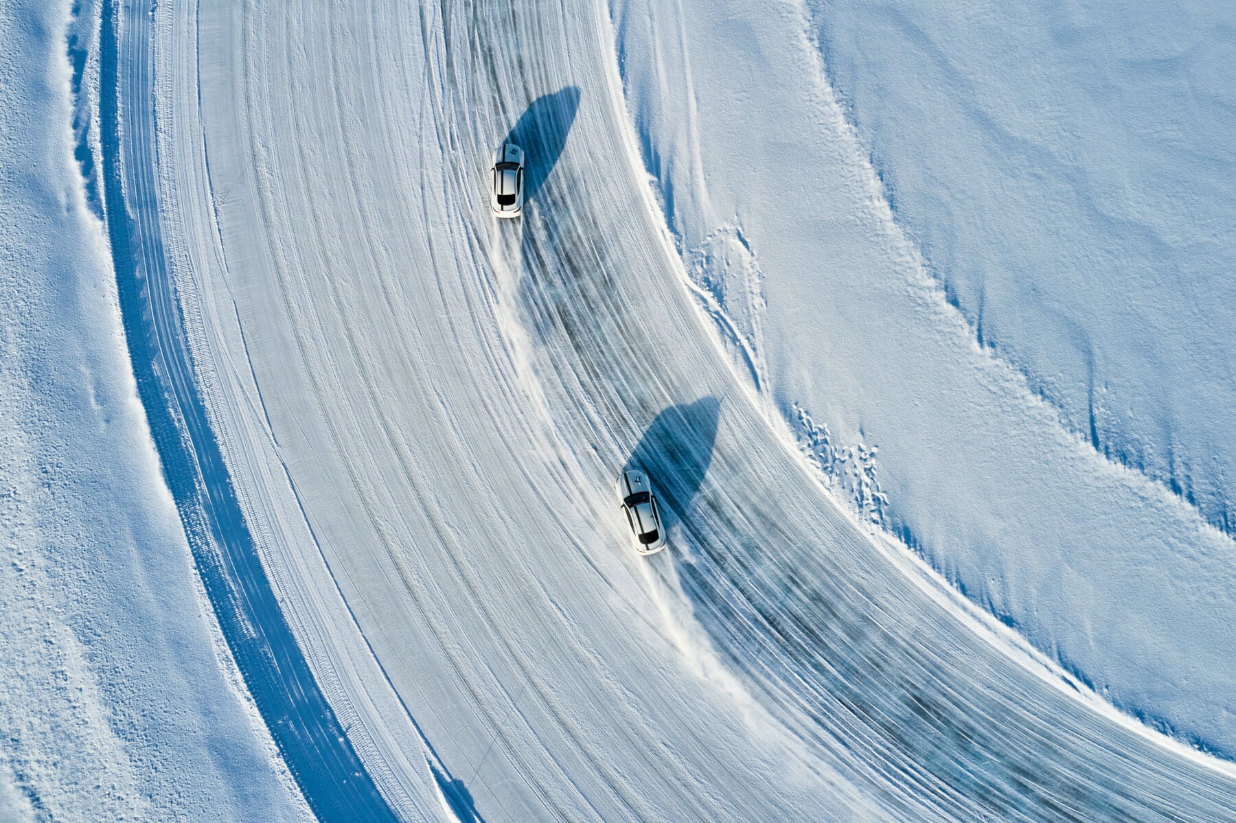 Zwei Fahrzeuge driften über einen zugefrorenen See in Schweden