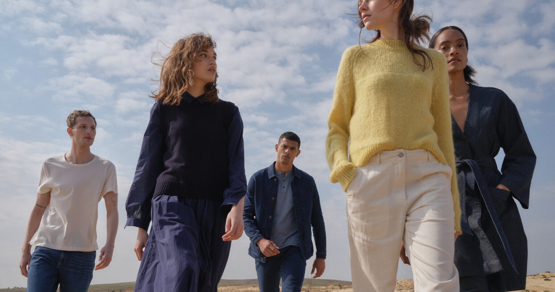 Mehrere Models am Strand, die alle unterschiedliche Outfits von Hessnatur tragen