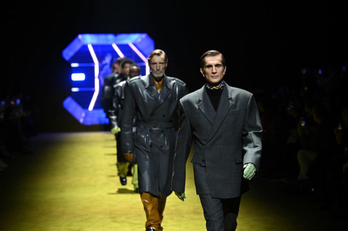 Mehrere Models laufen über den Laufsteg und präsentieren Männermode von Prada Mehrere Models laufen über den Laufsteg und präsentieren Männermode von Prada