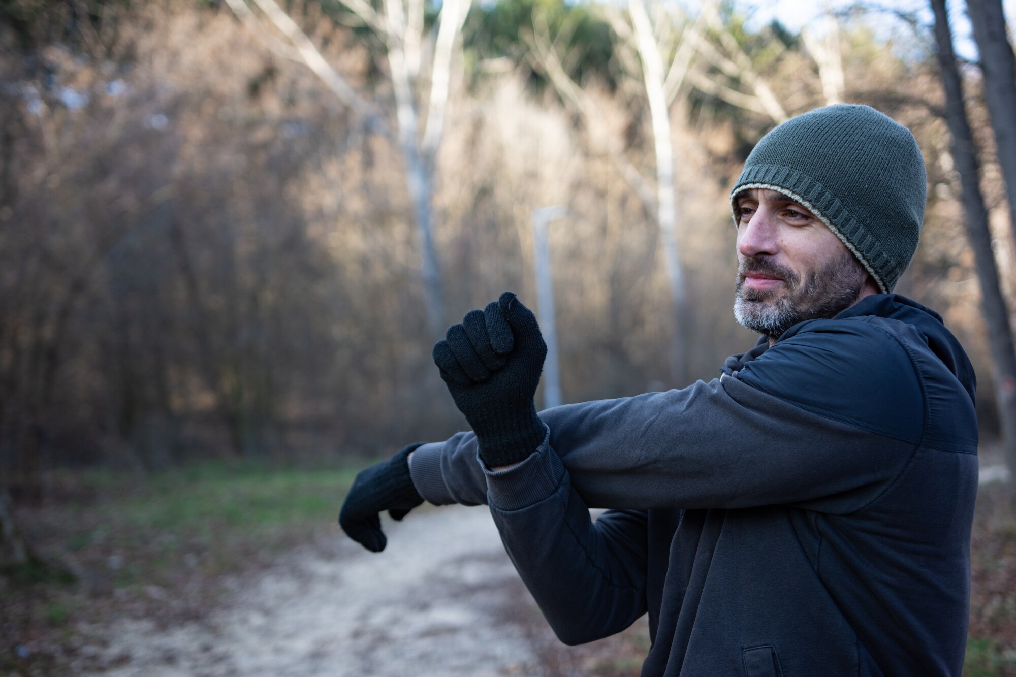 Ein Mann in Sportkleidung dehnt seinen Arm