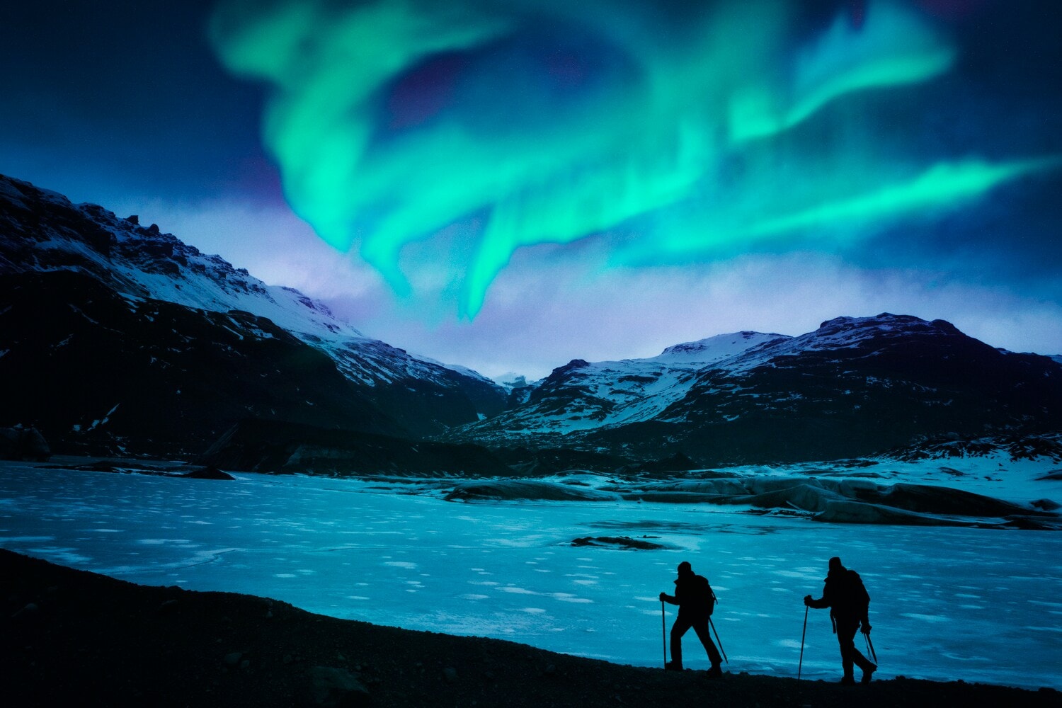 Zwei Wanderer vor einer Bergkulisse mit Polarlichtern. Zwei Wanderer vor einer Bergkulisse mit Polarlichtern.