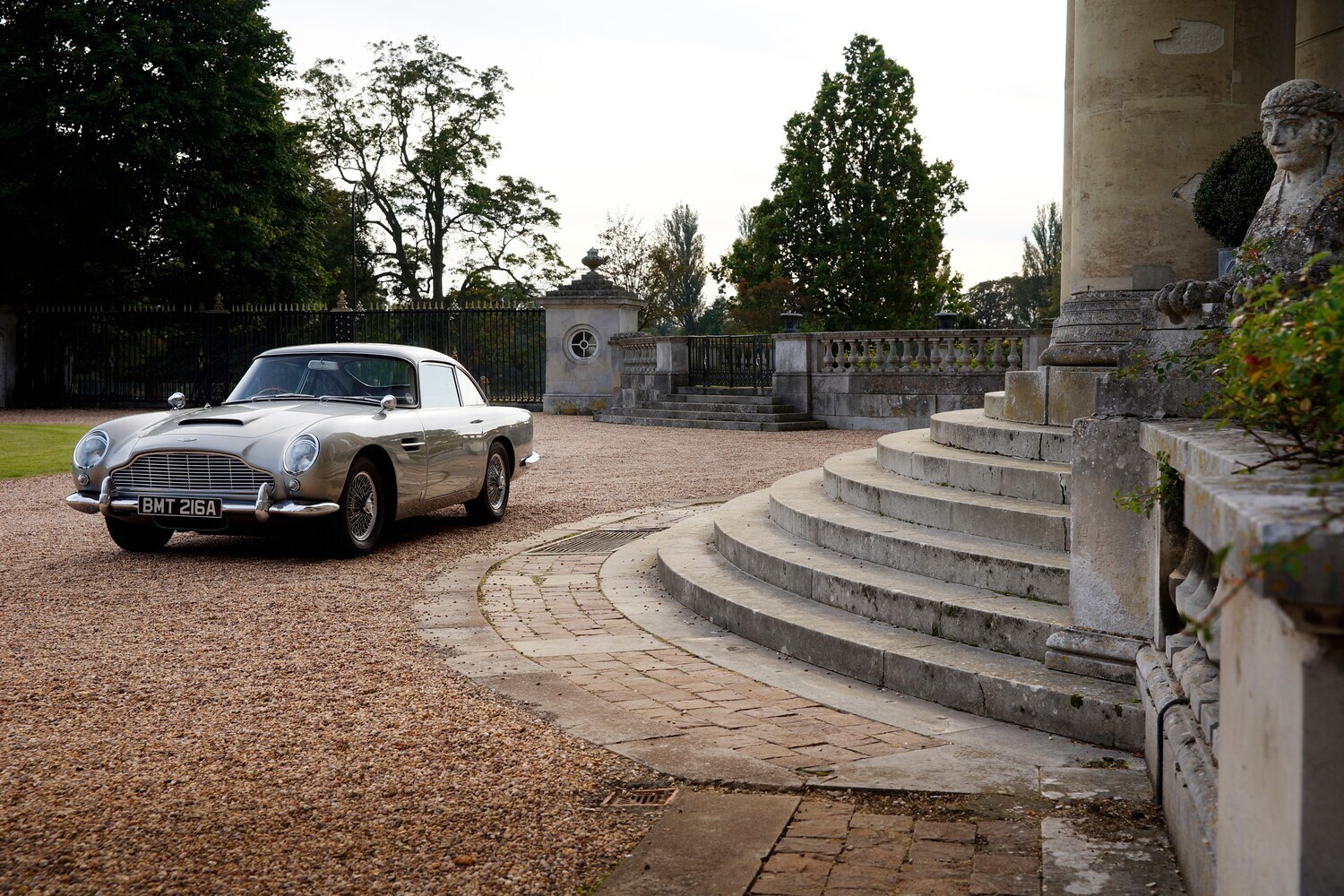 Ein silbergrauer Aston Martin DB5 von vorne links fotografiert.