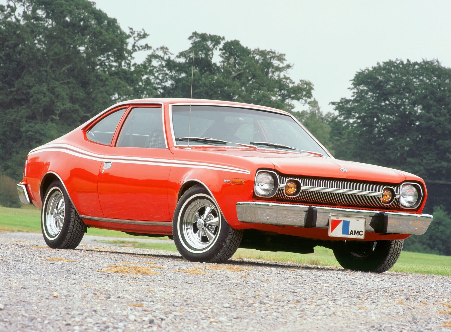 Der rote 74er AMC Hornet aus dem Film “Der Mann mit dem goldenen Colt” steht auf einem Parkplatz Der rote 74er AMC Hornet aus dem Film “Der Mann mit dem goldenen Colt” steht auf einem Parkplatz
