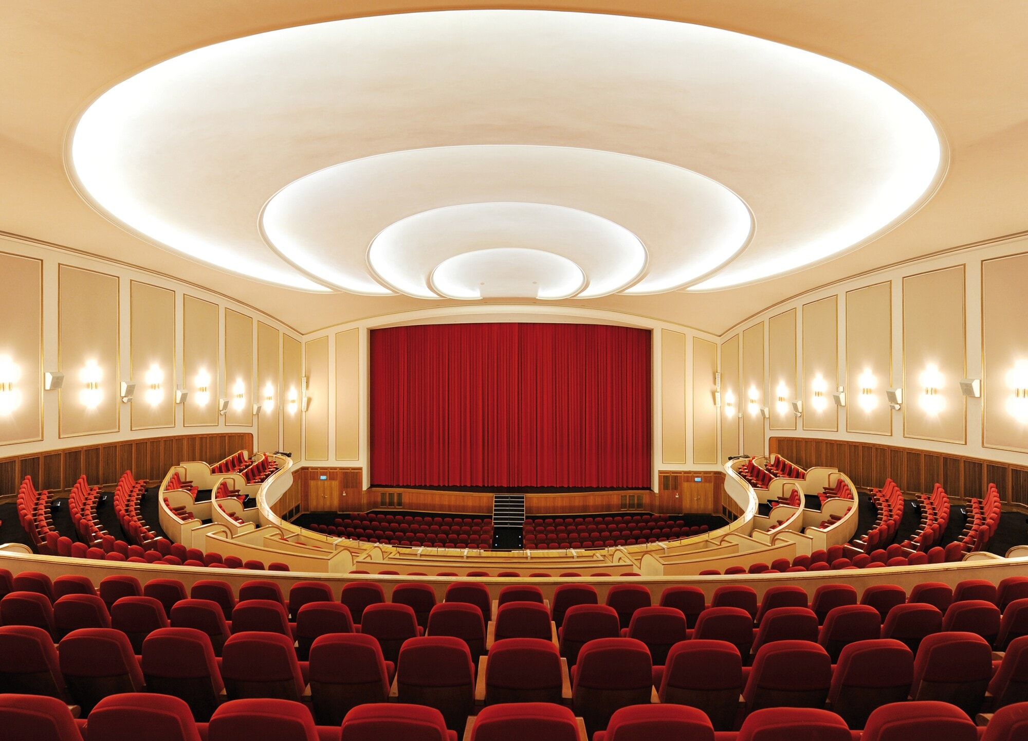 Großer Kinosaal mit Bühne und roten Stühlen Großer Kinosaal mit Bühne und roten Stühlen