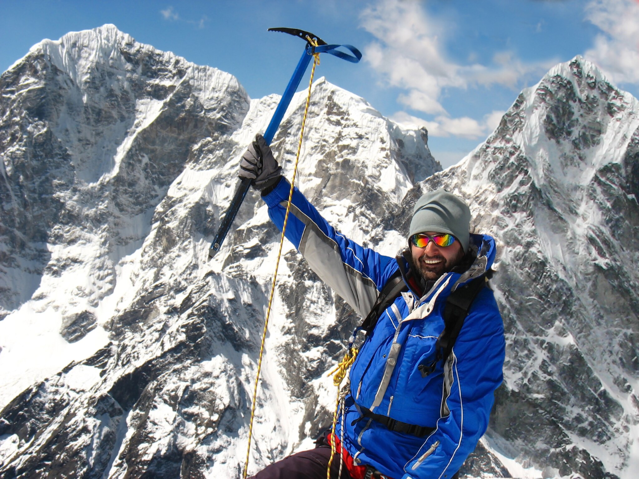Ein Bergsteiger mit Ausrüstung vor einem schneebedeckten Berg