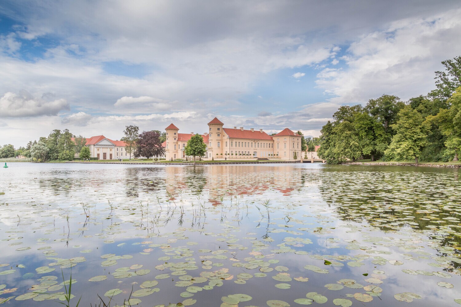 Schloss Rheinsberg spiegelt sich im Wasser.