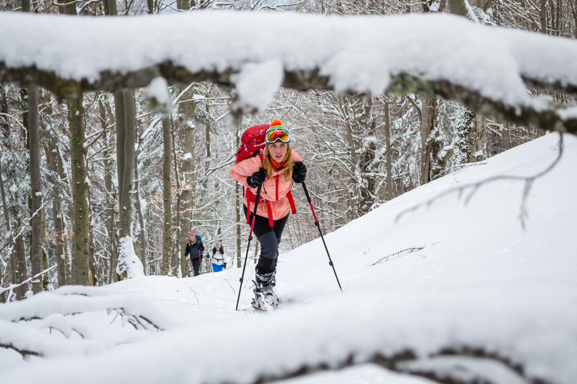 Eine Frau in Skibekleidung geht einen schneebedeckten Berg hinauf