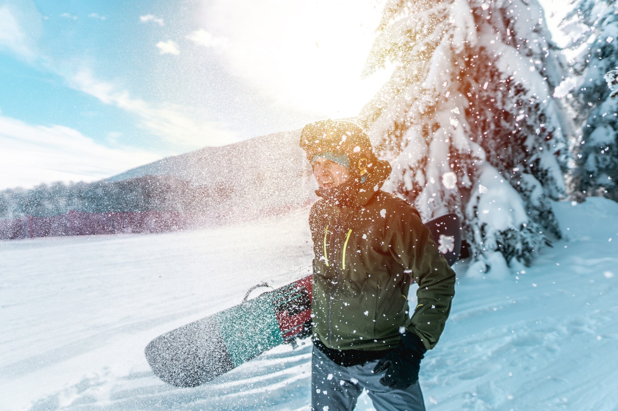 Ein junger Mann mit einem Snowboard unter dem Arm