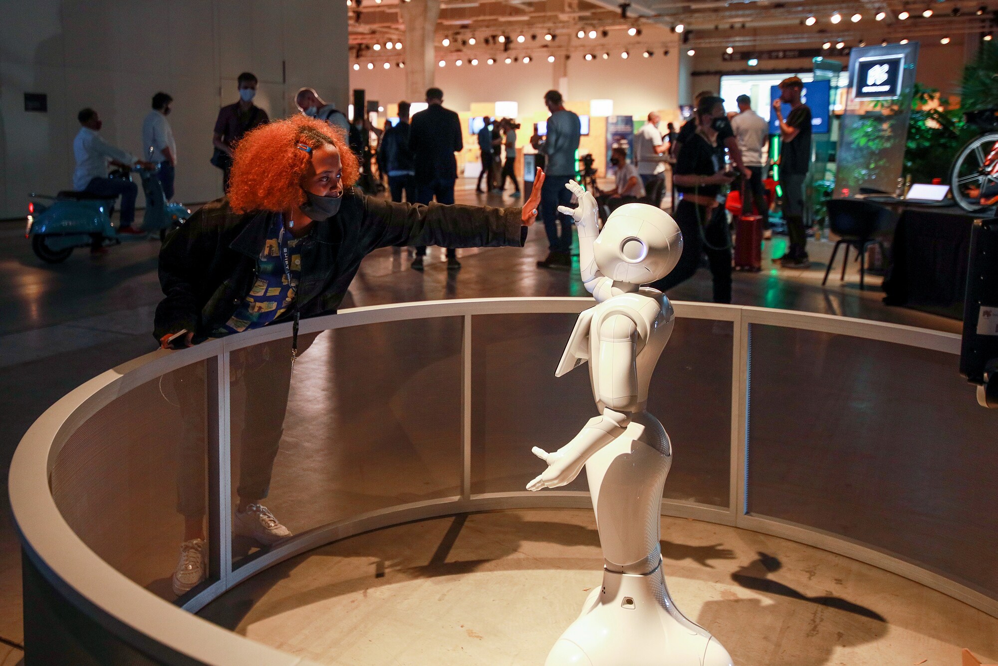 Messebesucherin gibt einem Roboter einen High Five