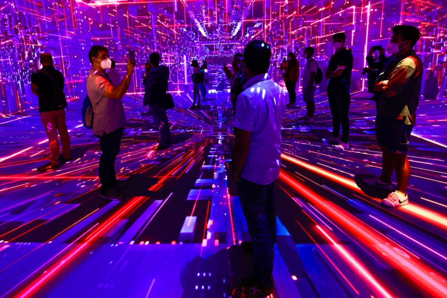 Messebesucher in Barcelona in einem Raum voller roter und blauer Lichtstrahlen