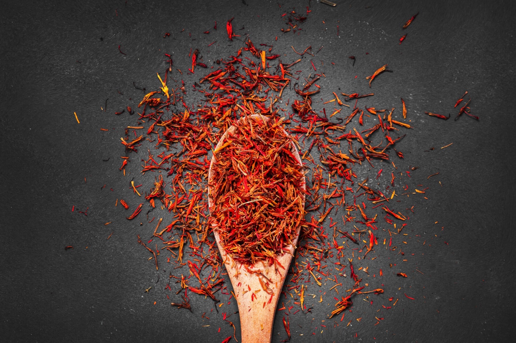 Getrocknete Safranfäden auf einem Holzlöffel Getrocknete Safranfäden auf einem Holzlöffel