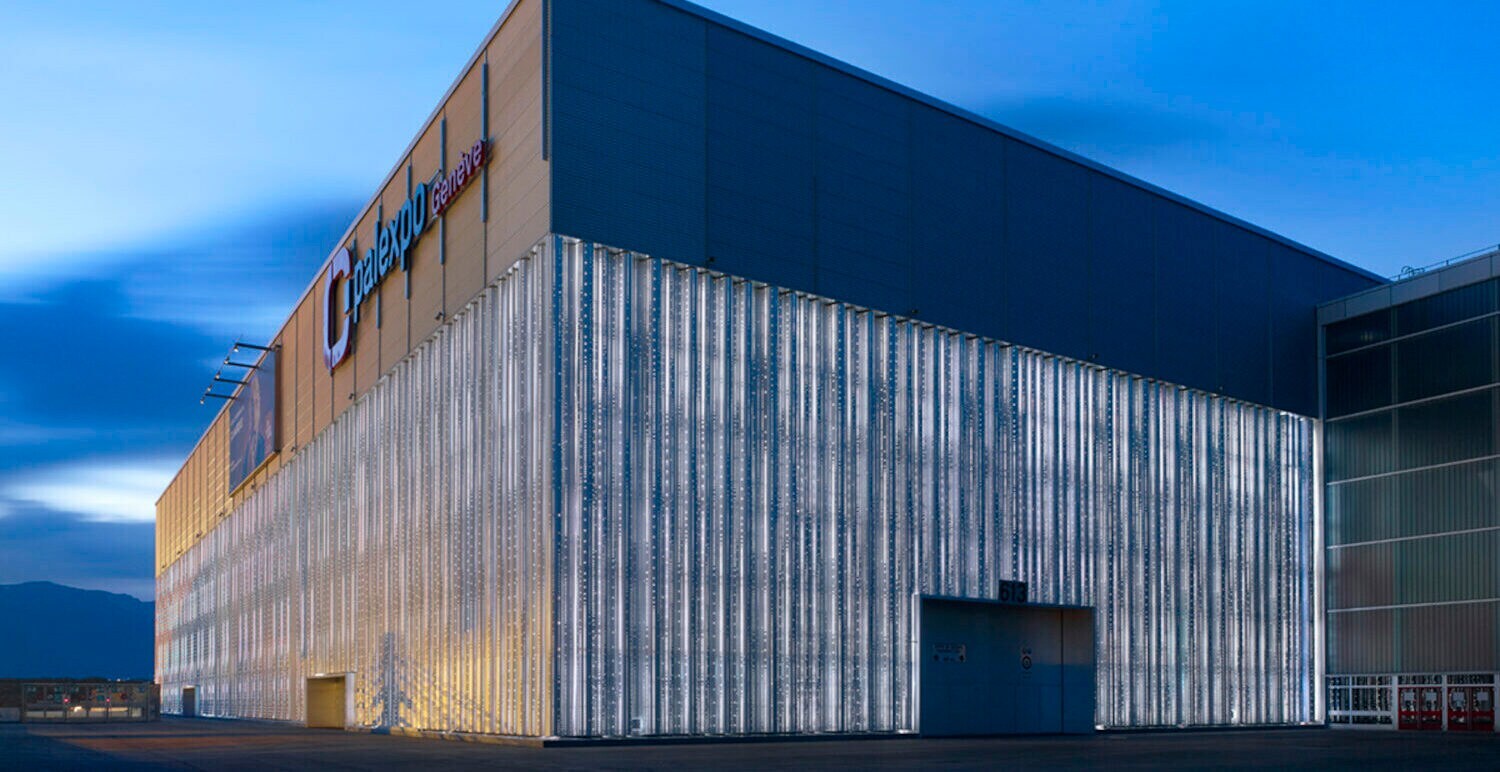 Ein großes, modernes Gebäude vor einem Abendhimmel