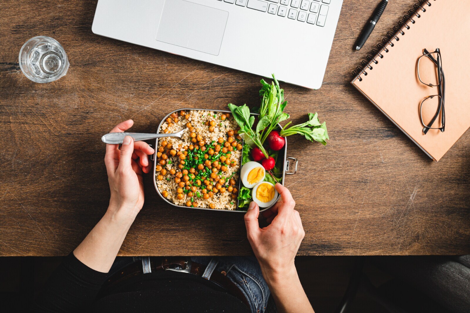 Aufsicht einer Person beim Essen einer gesunden Mahlzeit am Schreibtisch
