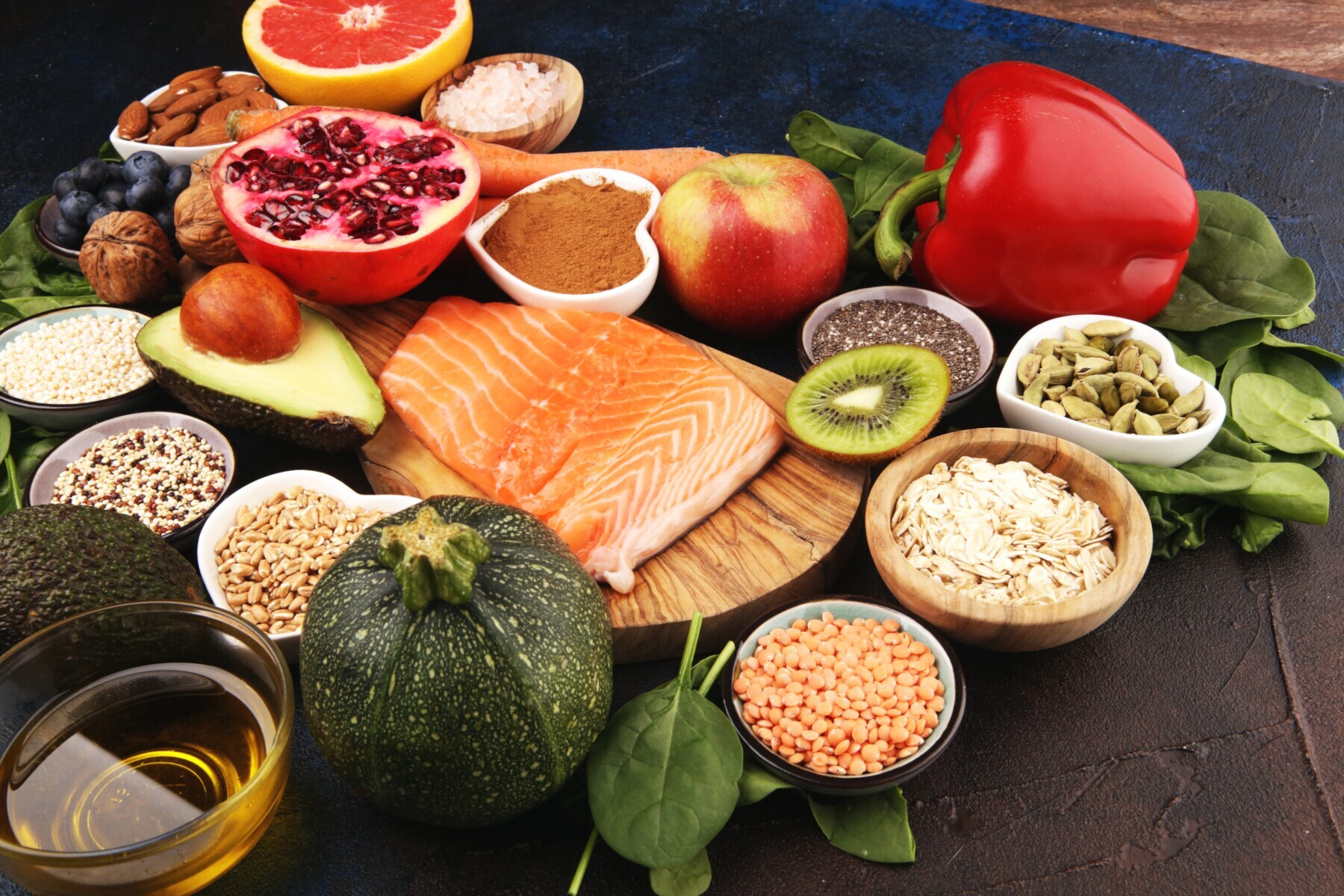 Frisches Obst, Gemüse, Lachs und Körner auf einem rustikalen Untergrund