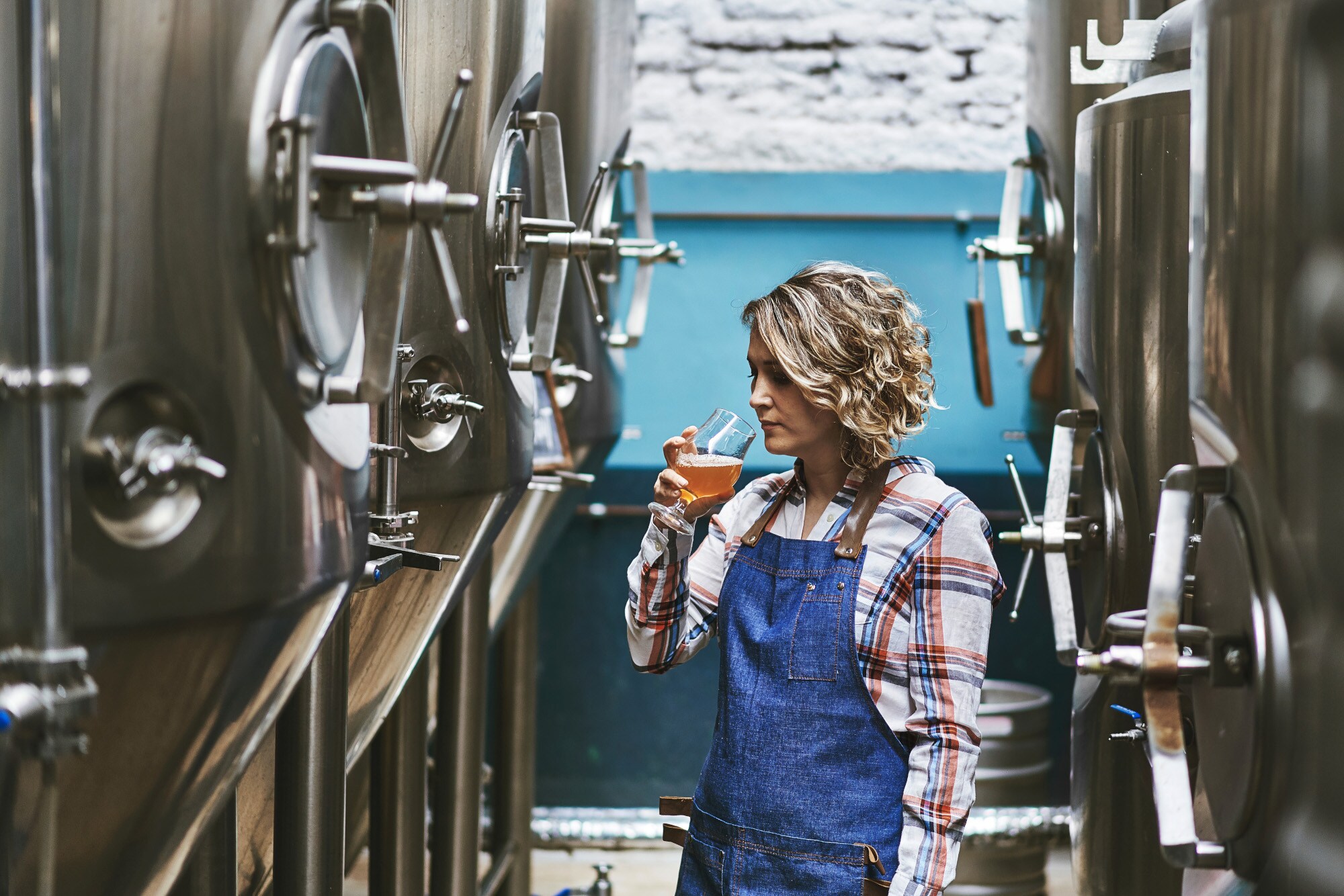 Eine Frau bei einer Bierprobe zwischen Zapffässern Eine Frau bei einer Bierprobe zwischen Zapffässern