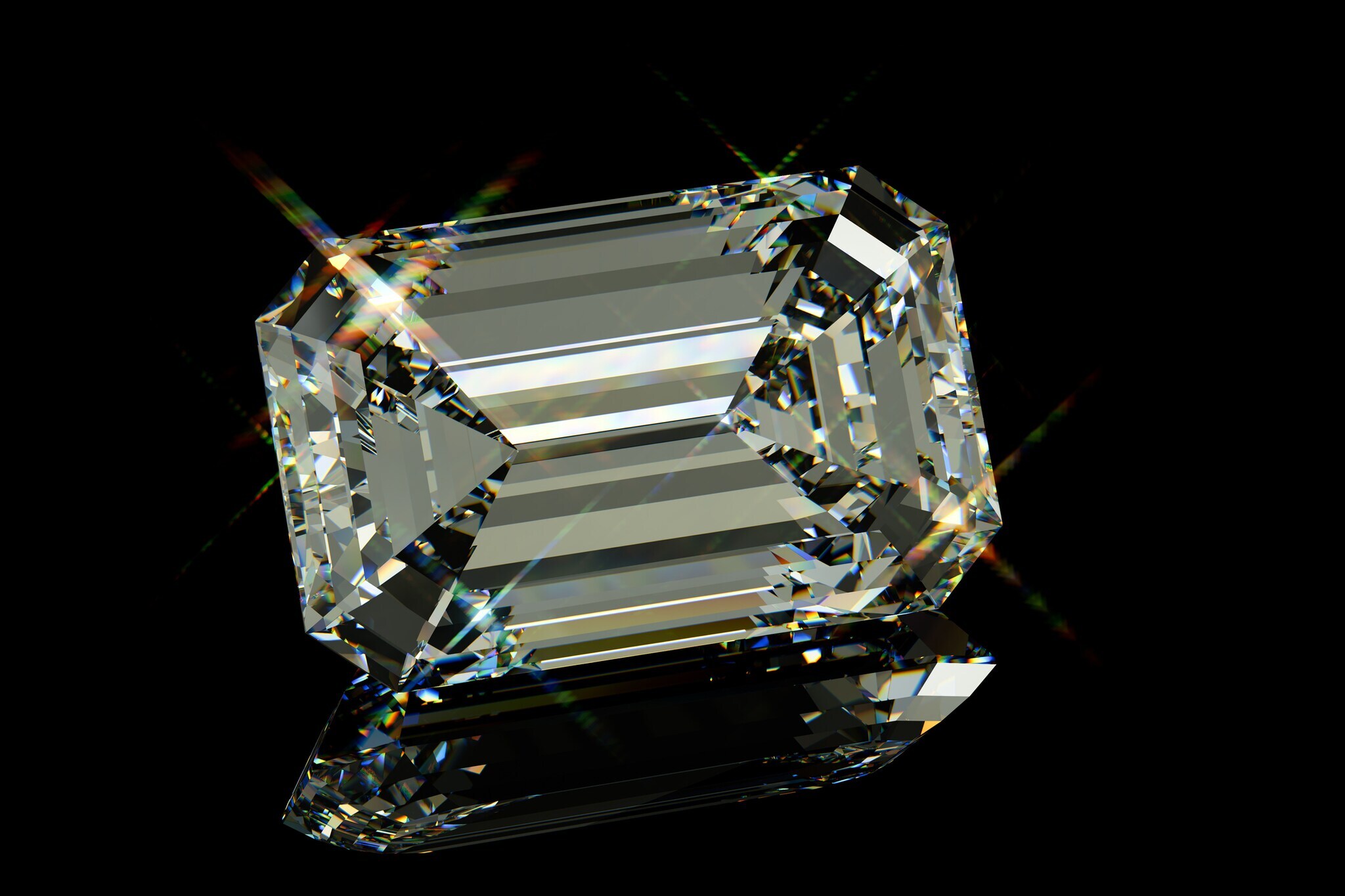 Ein Diamant mit Smaragdschliff vor schwarzem Hochglanz-Hintergrund.