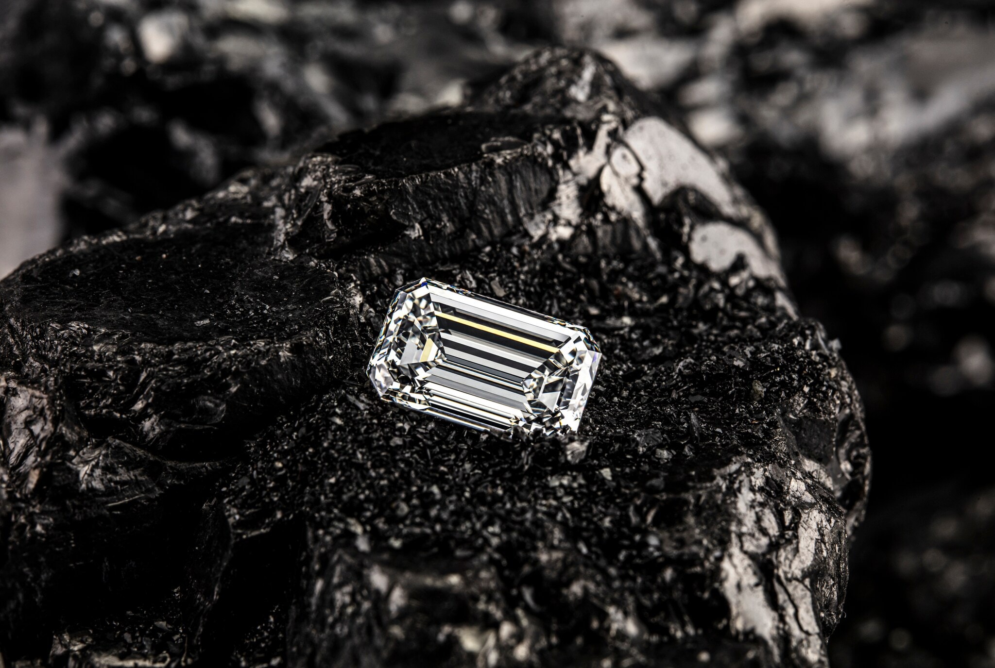 Einzelner Smaragddiamant auf schwarzem Kohlehintergrund. Einzelner Smaragddiamant auf schwarzem Kohlehintergrund.