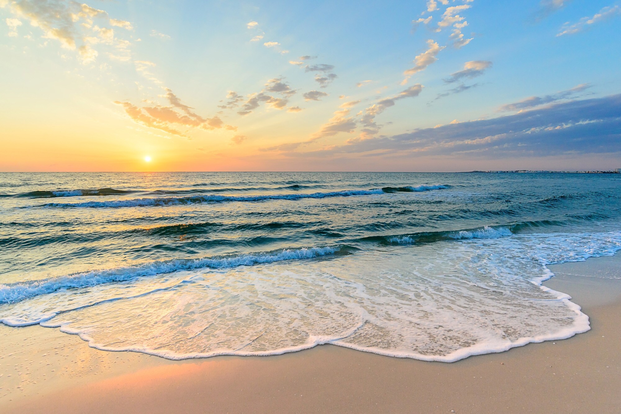 Ein Strand, an dem kleine Wellen ankommen