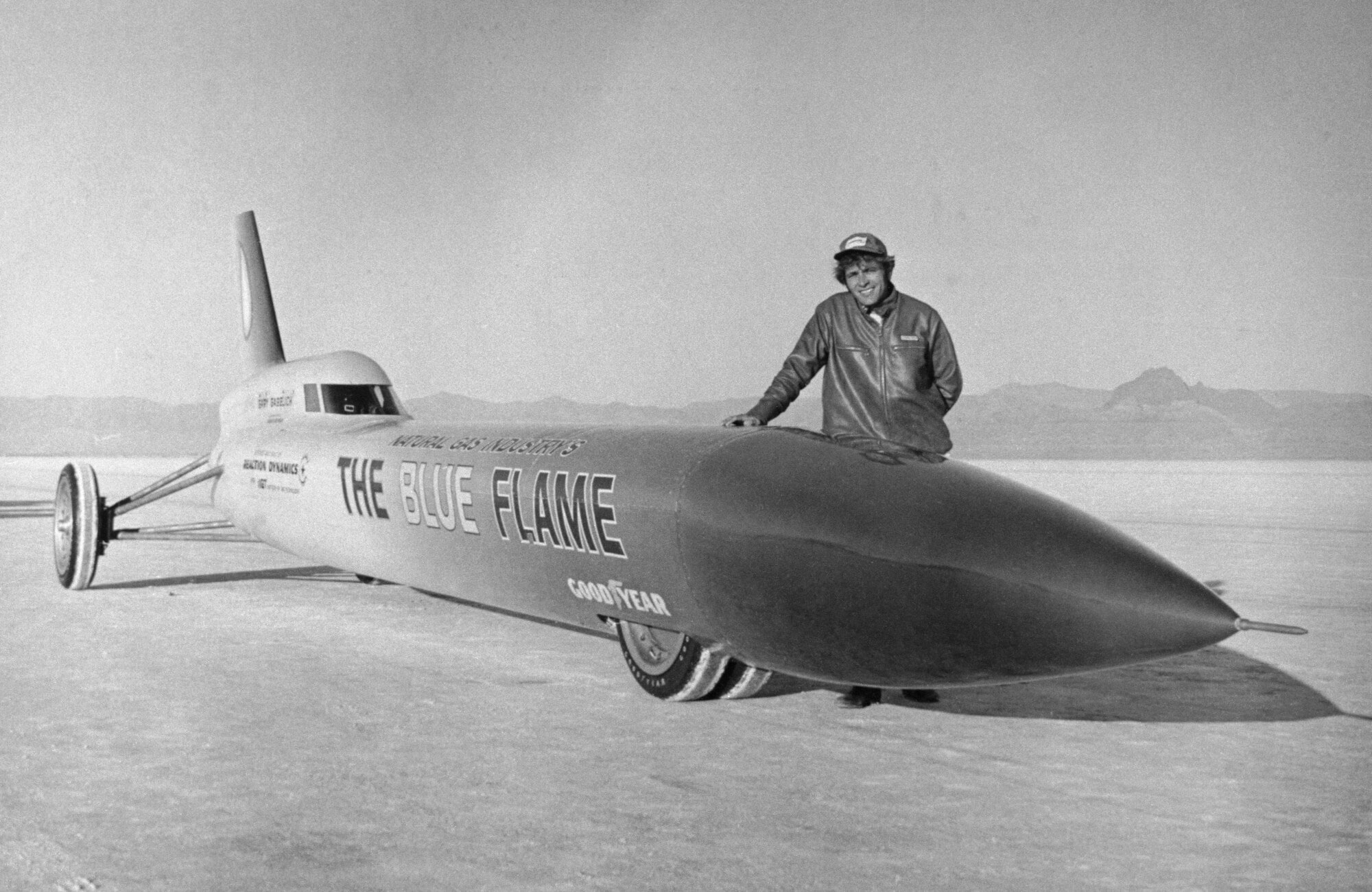 Historische Aufnahme des Rennwagenfahrers Gary Gabelich neben seinem Auto The Blue Flame Historische Aufnahme des Rennwagenfahrers Gary Gabelich neben seinem Auto The Blue Flame