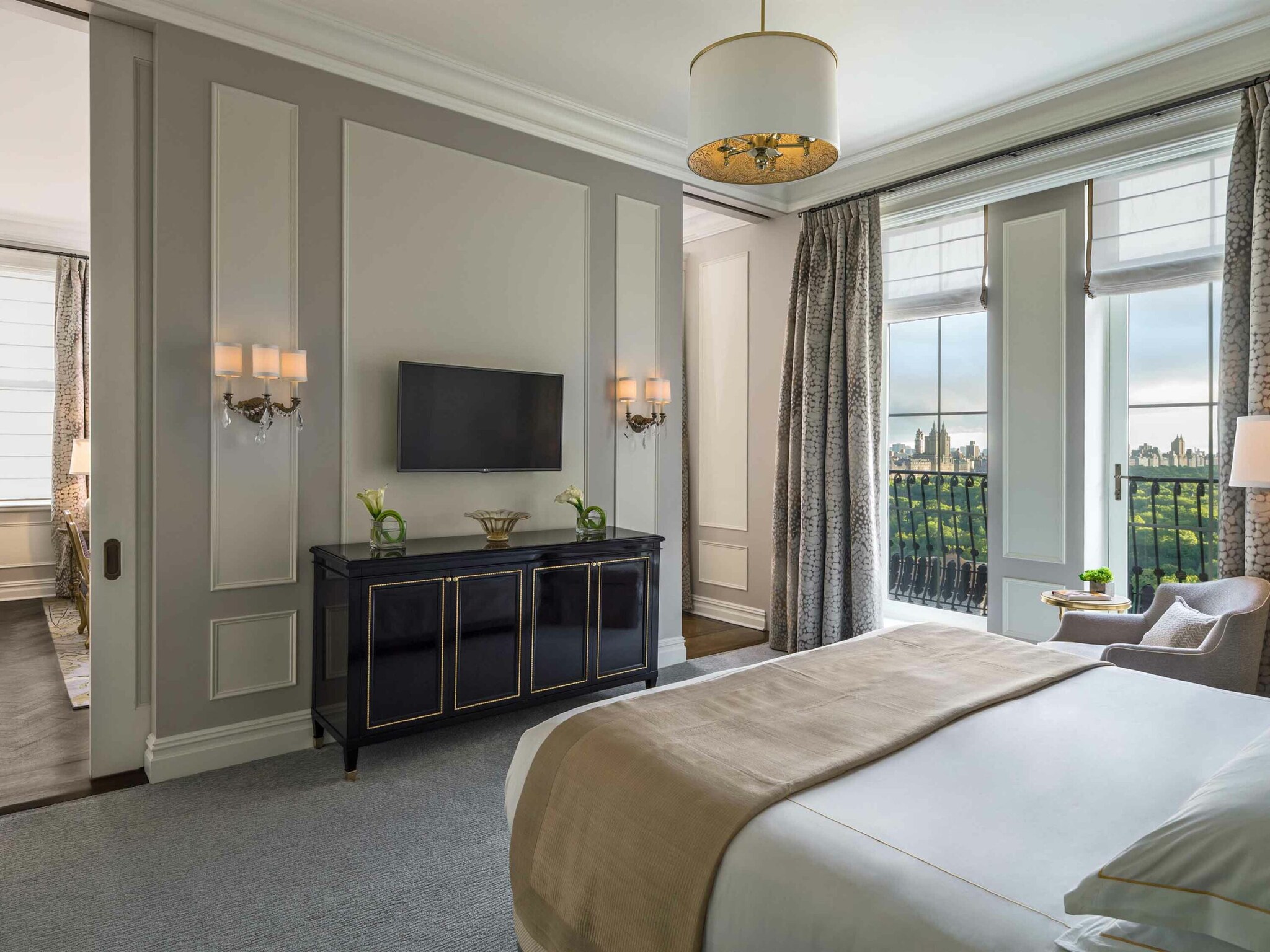 Hotelzimmer in hellen Farben, im Mittelpunkt ein Bett und große Fenster