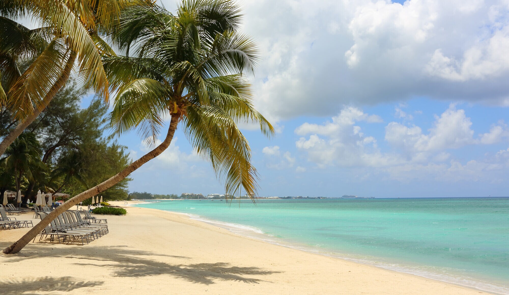 Ein Sandstrand vor türkisblauem Wasser Ein Sandstrand vor türkisblauem Wasser