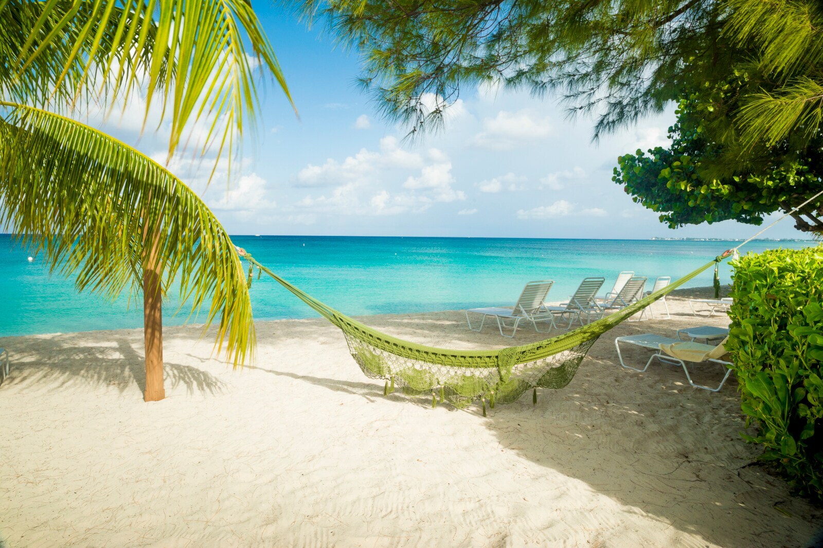 Eine Hängematte hängt am Sandstrand auf Jamaika
