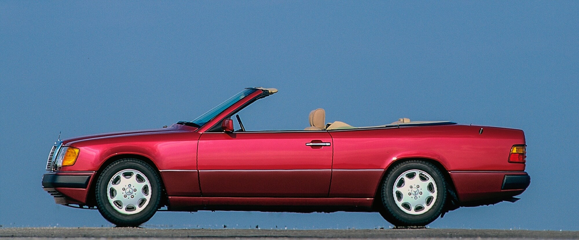 Ein rotes Mercedes-Cabriolet der Baureihe W 124 von der Seite Ein rotes Mercedes-Cabriolet der Baureihe W 124 von der Seite