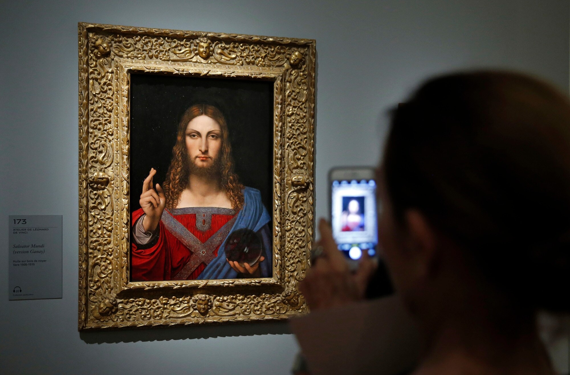 Rückansicht einer Person, die mit seinem Smartphone ein Gemälde von Leonardo da Vinci an einer Wand im Museum fotografiert Rückansicht einer Person, die mit seinem Smartphone ein Gemälde von Leonardo da Vinci an einer Wand im Museum fotografiert