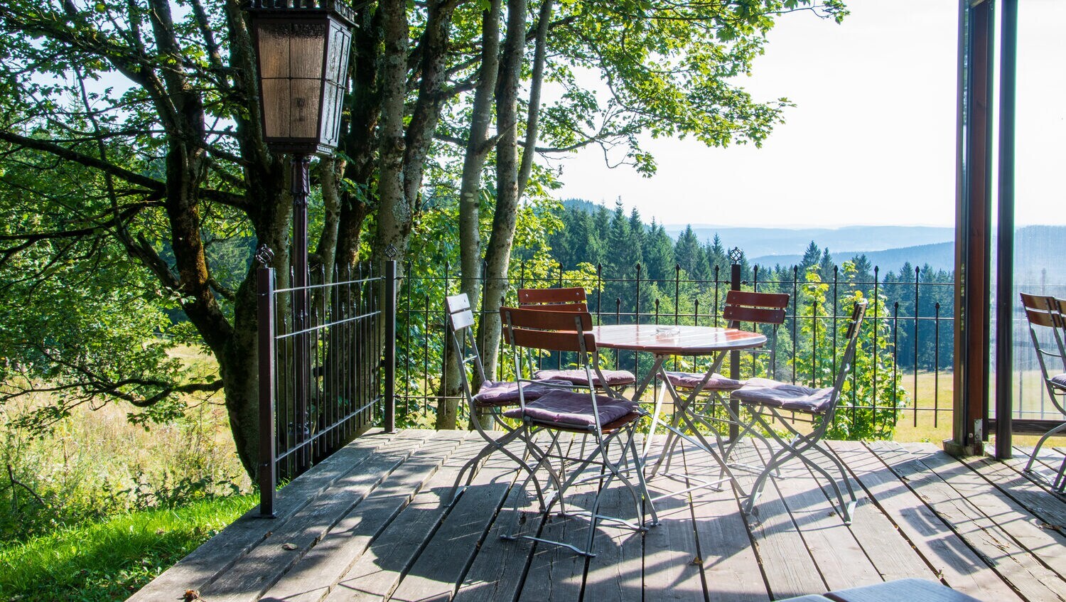 Die Terrasse eines Biergartens auf einem Berg, im Hintergrund weitläufige Landschaft