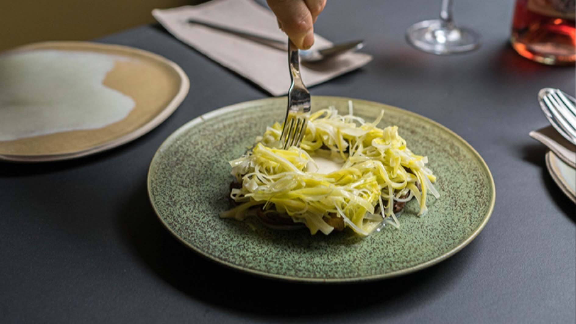 Eine Gabel wickelt Gemüse auf einem Teller auf