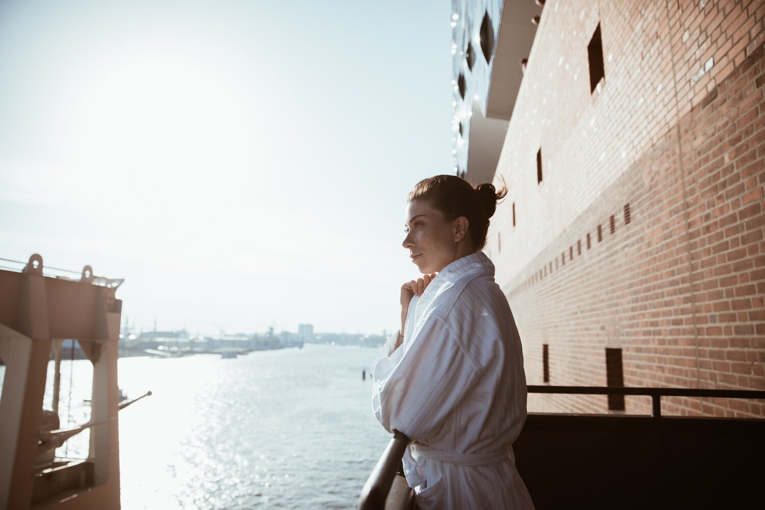 Eine Frau im Bademantel schaut von einem Balkon über die Elbe. Eine Frau im Bademantel schaut von einem Balkon über die Elbe.