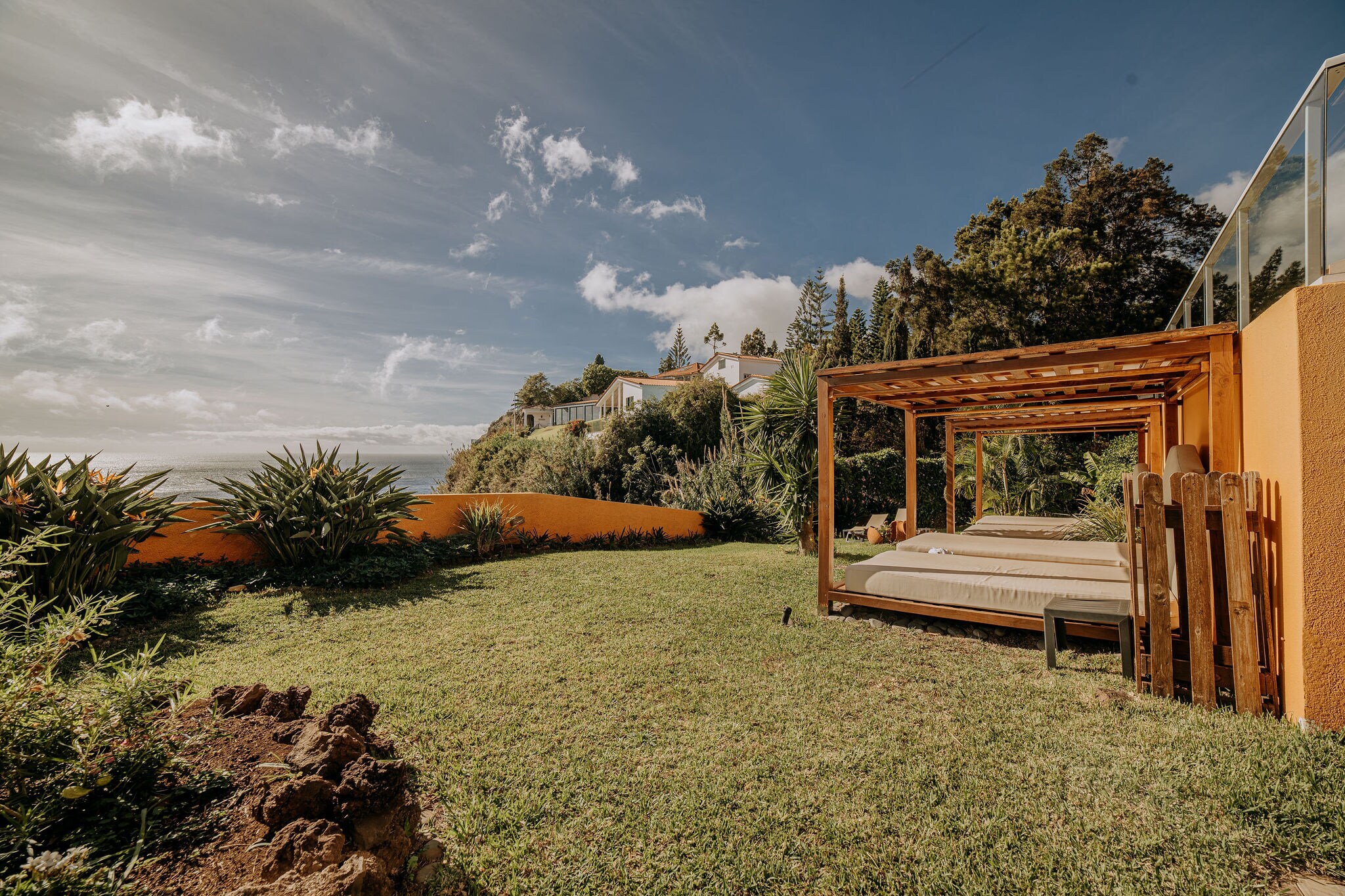 Außenanlage eines Hotels an der Küste mit Sonnenliegen