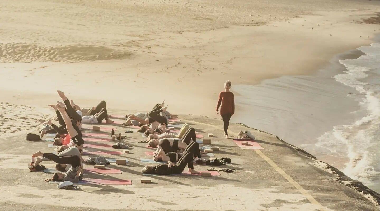 Eine Gruppe macht Yoga am Strand