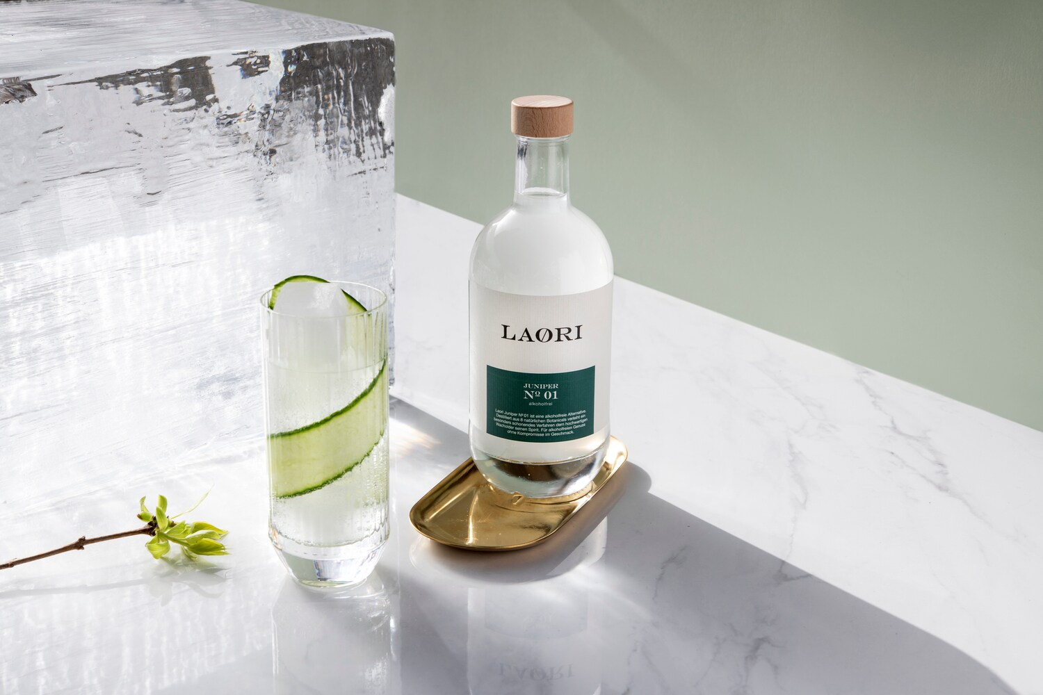 Flasche der Marke Laori neben einem Glas und Eisblock.