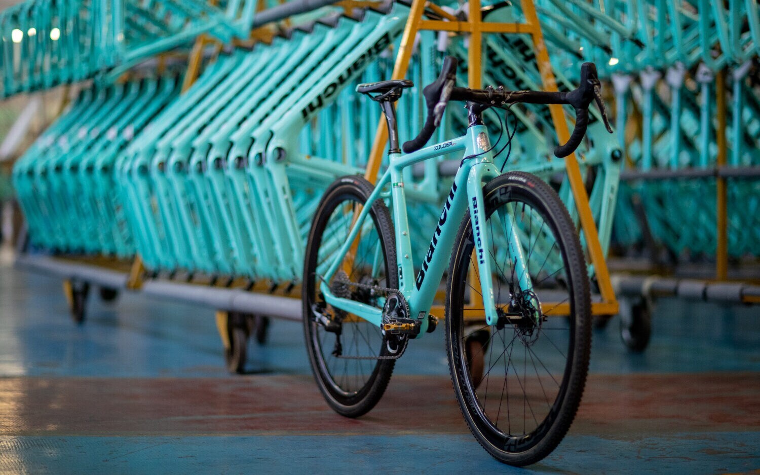 In einer Fabrik sind Rennradrahmen von Bianchi aufgereiht.