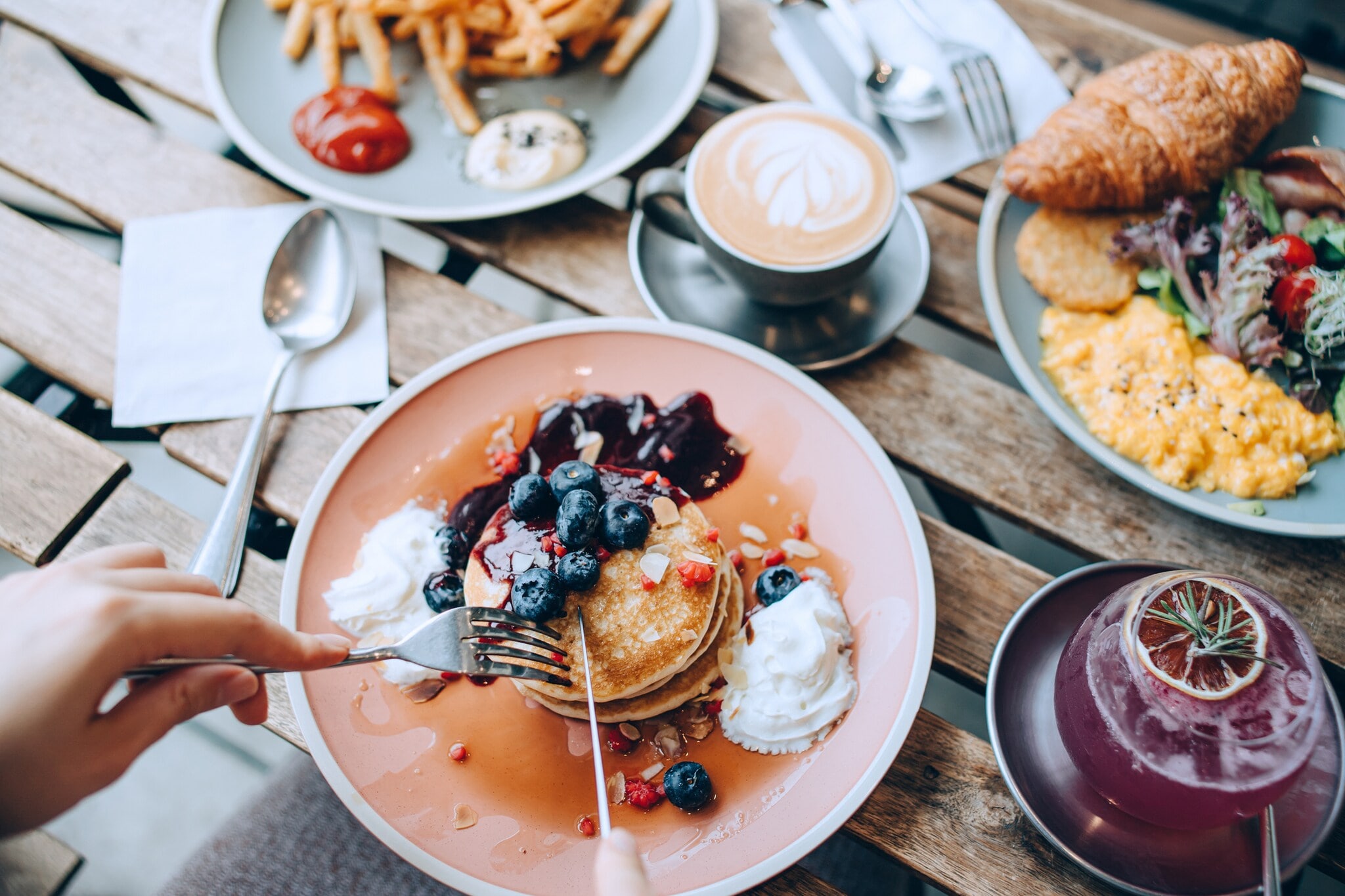 Drei üppig mit Essen befüllte Teller, darunter Pfannkuchen. Drei üppig mit Essen befüllte Teller, darunter Pfannkuchen.