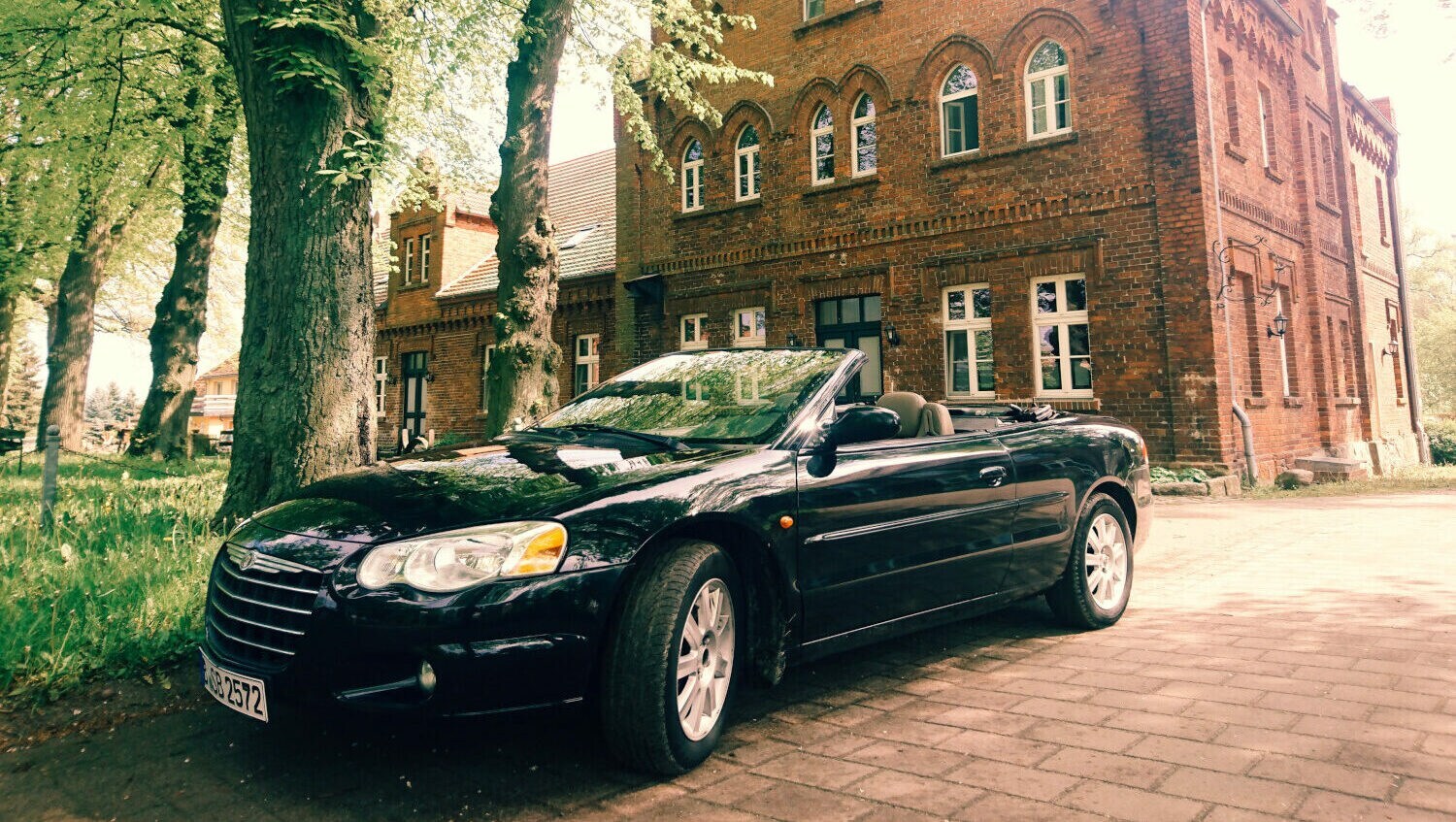Ein schwarzes Cabrio vor einem alten Gebäude Ein schwarzes Cabrio vor einem alten Gebäude