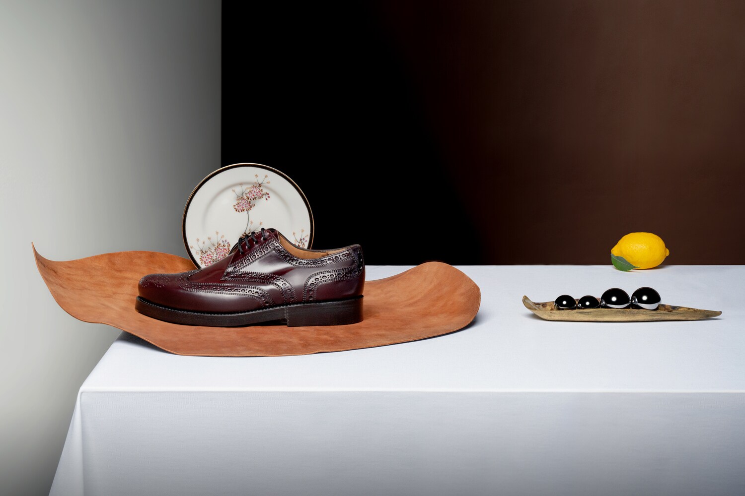 Ein Herrenschuh liegt auf einem Tisch mit weißer Tischdecke.